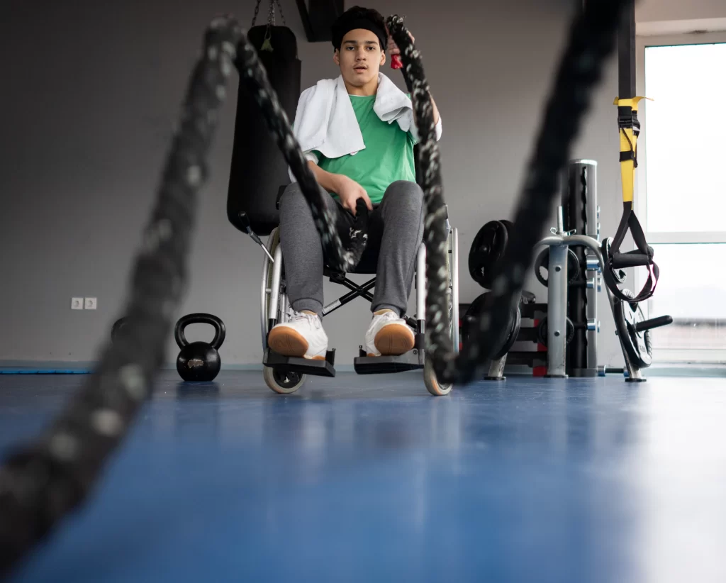 Teenage boy in wheelchair doing rope workout